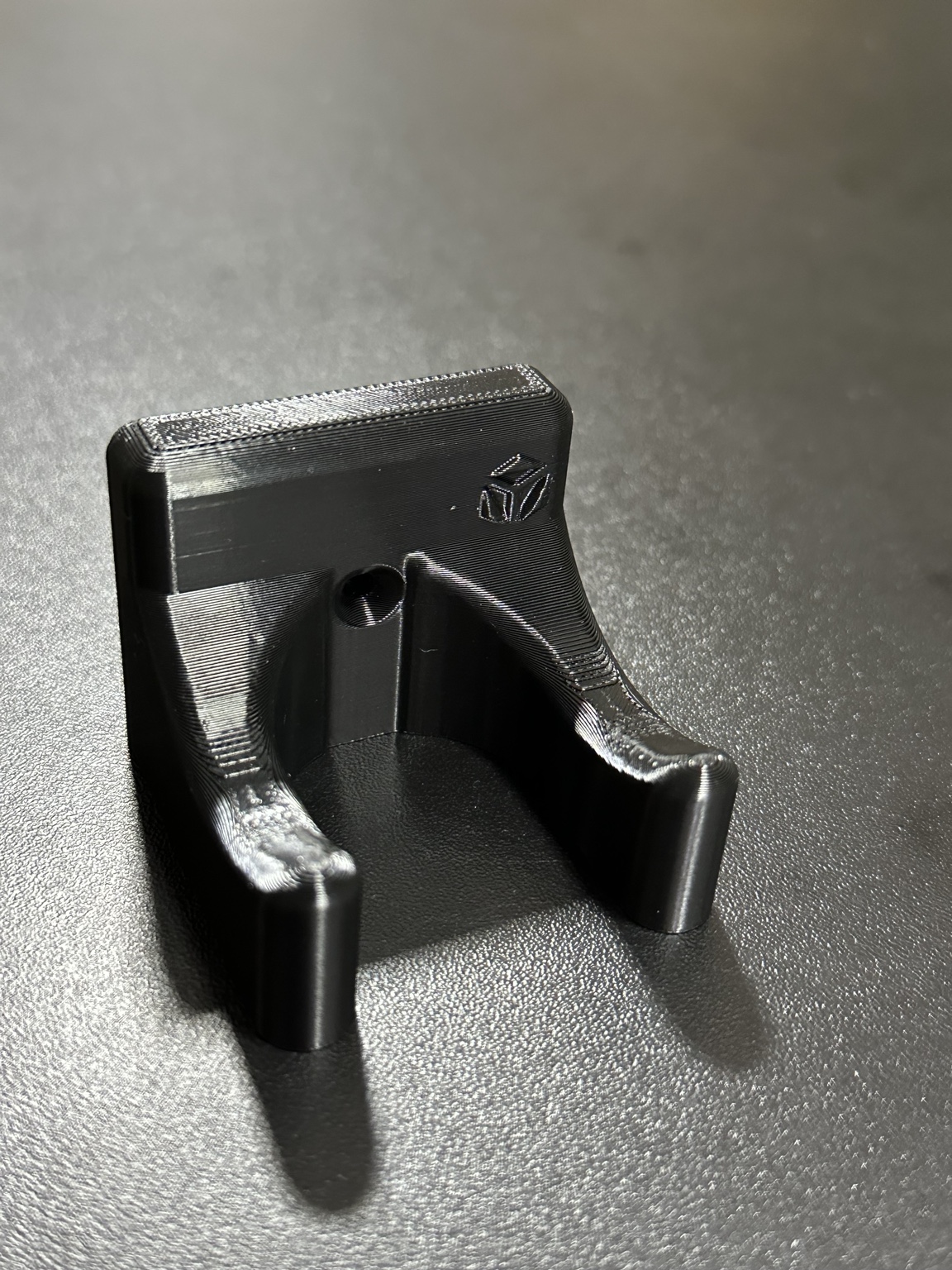 Suporte preto impresso em 3D com encaixe curvo e base de fixação